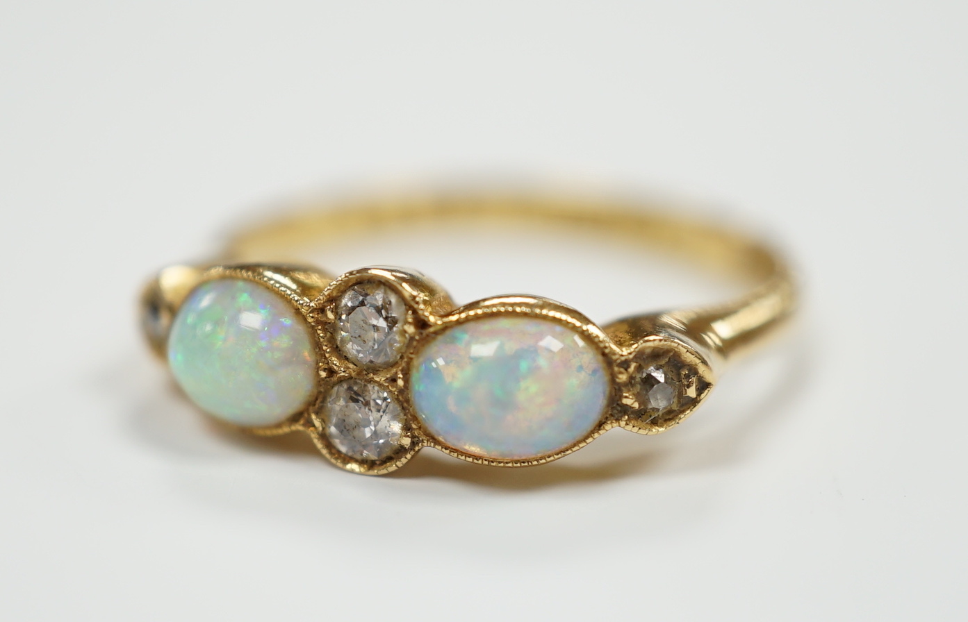 A George V 18ct gold, two stone white opal and four stone diamond chip set half hoop ring, Birmingham, 1917, size P, gross weight 3.6 grams.